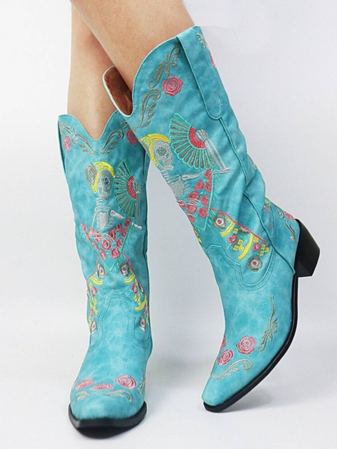 blue mid-calf cowgirl boots with multicolor skeleton embroidery, featuring a snip toe and block heel.